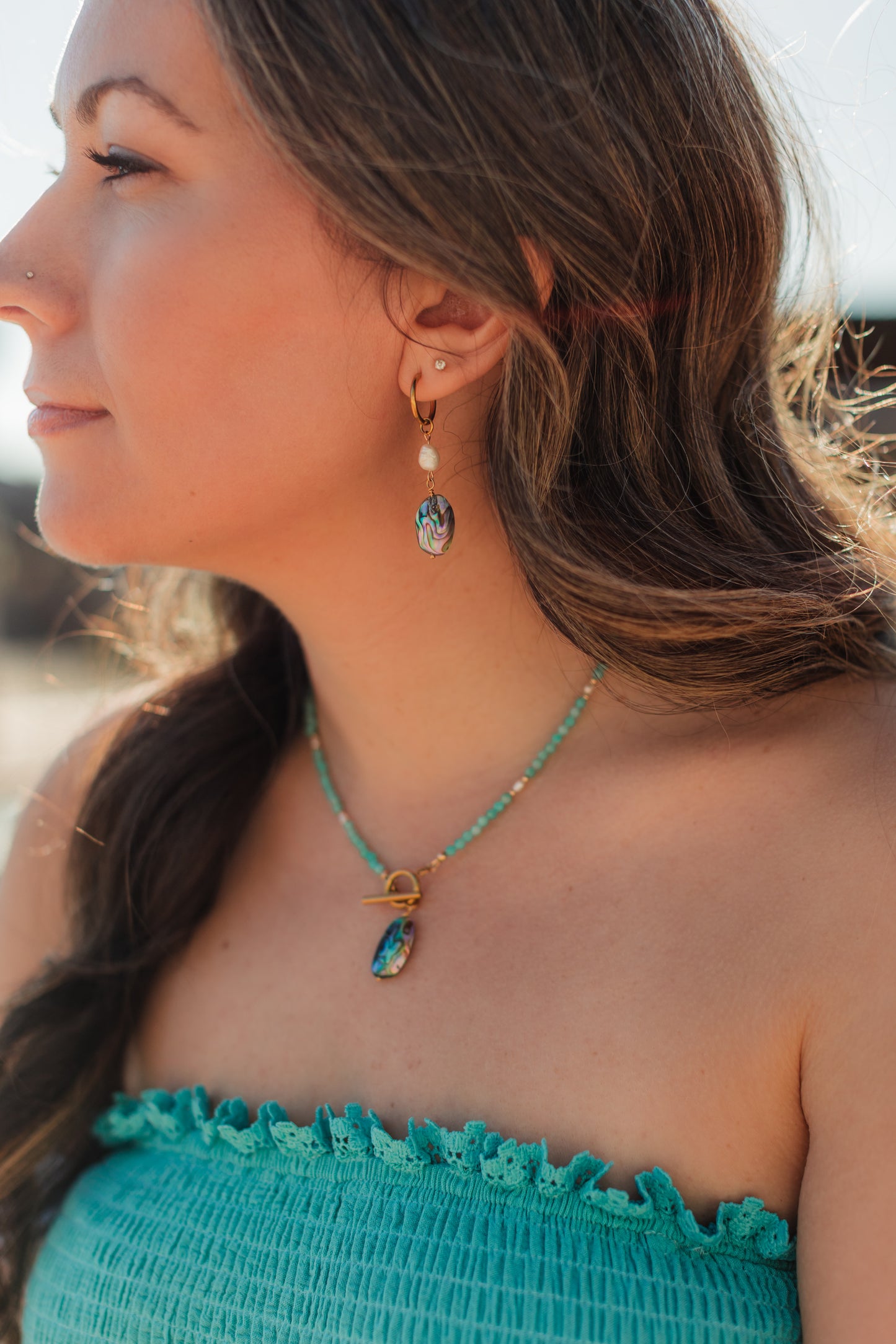 Afterglow Abalone Earrings worn – coastal gold huggie earrings with pearl and abalone.