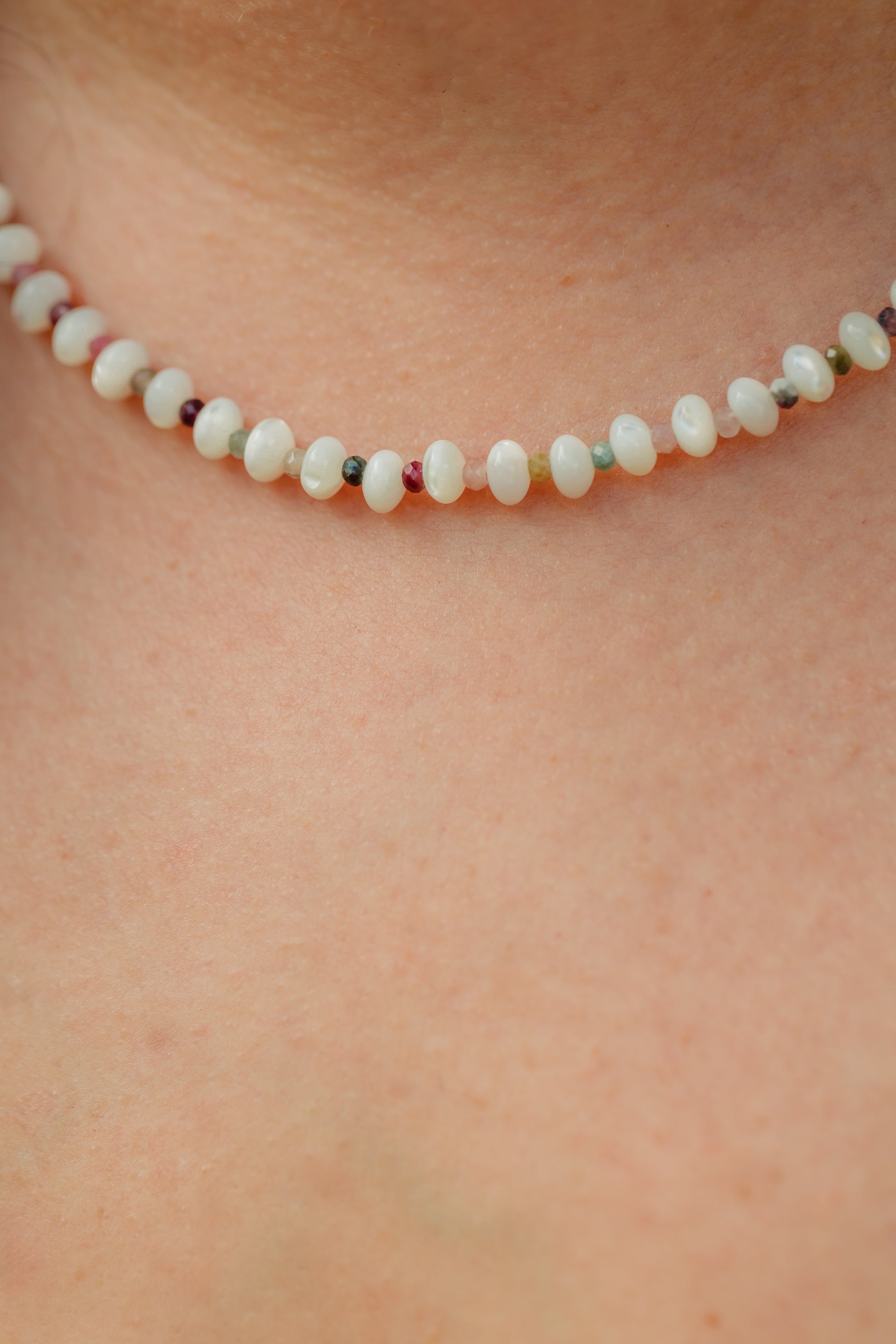 Hand-strung necklace featuring genuine mother of pearl rondelles, faceted watermelon tourmaline gemstones, and 18K Gold PVD hardware inspired by tropical coastal style.