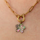 Gold necklace with a colorful flower pendant on a person's neck