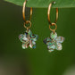 Hand-carved genuine abalone shell plumeria flower earrings suspended from 18K Gold PVD stainless steel hoop earrings with naturally iridescent ocean-inspired colors.