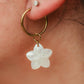 Hand-carved genuine mother of pearl plumeria flower earrings suspended from 18K Gold PVD stainless steel hoop earrings.