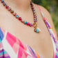 Hand-strung sea sediment jasper gemstone necklace featuring marbled berry, turquoise, and sandy neutral tones with a gold carabiner clasp and removable coastal-inspired charms.