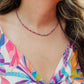 Hand-strung genuine faceted pink ruby gemstone necklace with 18K Gold PVD accents, inspired by the soft pink and purple colors of Hawaiian sunsets.