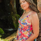 Woman in a colorful dress standing in front of a natural background