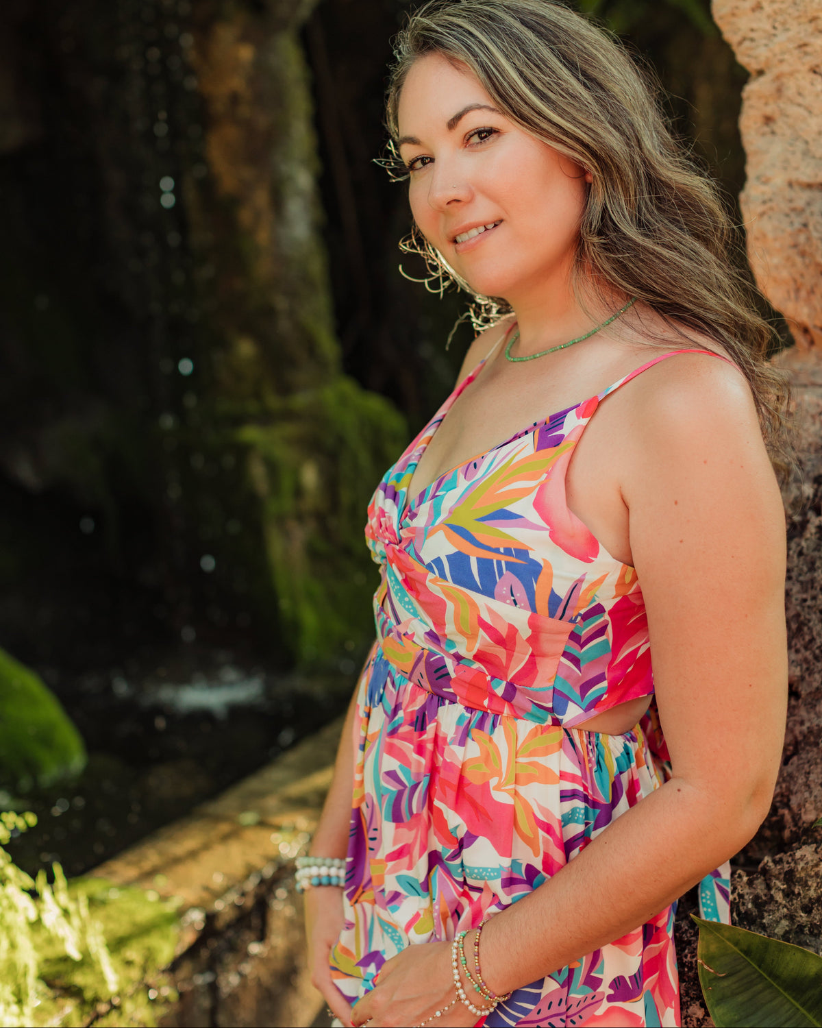 Woman in a colorful dress standing in front of a natural background
