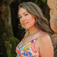 Woman in a colorful dress standing in front of a natural background