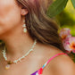 Sunrise Shell Coral Drop Earrings featuring genuine Hawaiian sunrise shells, natural coral chips, freshwater pearls, and 18K Gold PVD hoops inspired by the rare treasures of Hawaii.