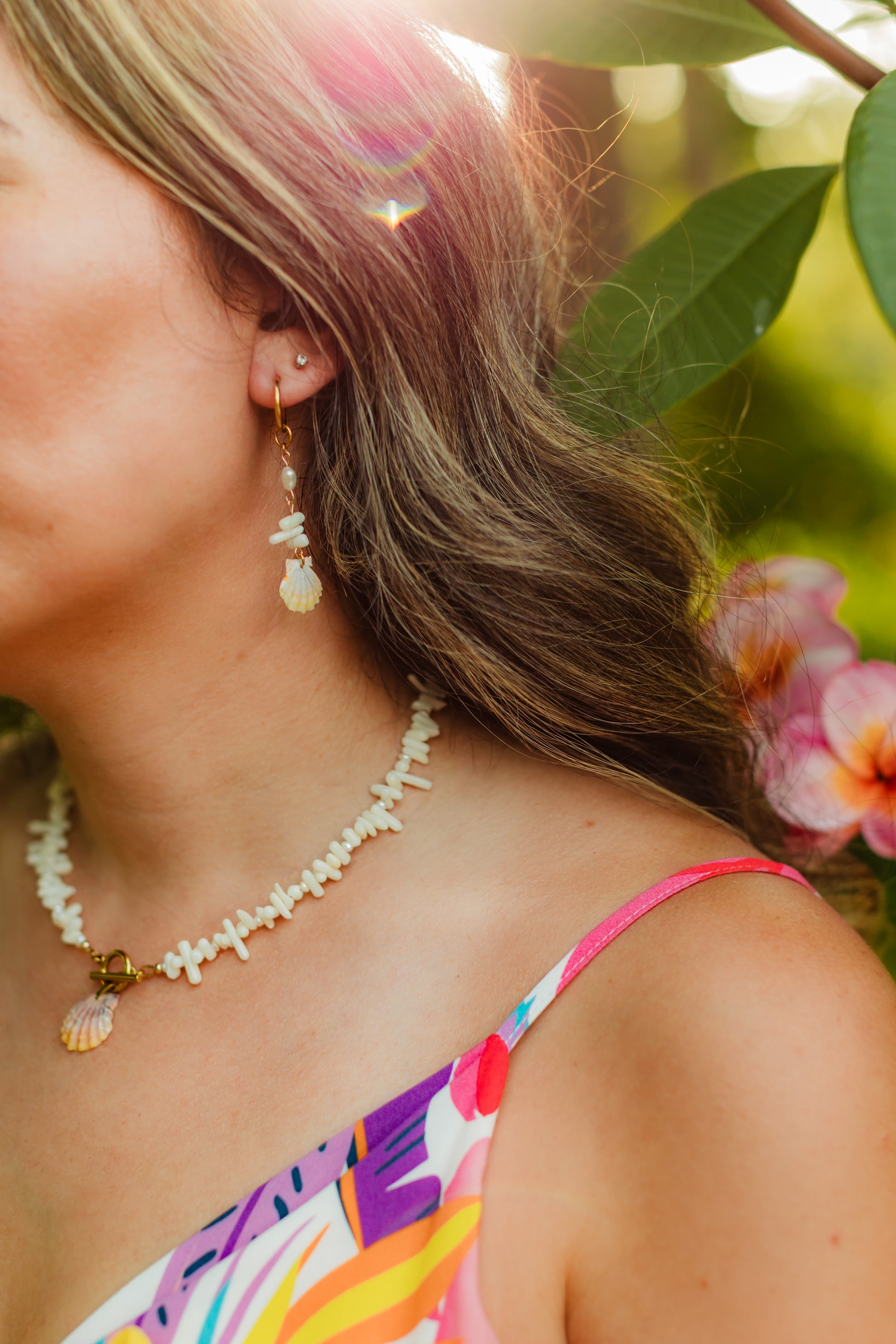 Sunrise Shell Coral Drop Earrings featuring genuine Hawaiian sunrise shells, natural coral chips, freshwater pearls, and 18K Gold PVD hoops inspired by the rare treasures of Hawaii.