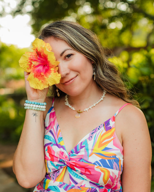 Woman wearing the Hawaiian Sunrise Shell Necklace with coral chips and freshwater pearl accents