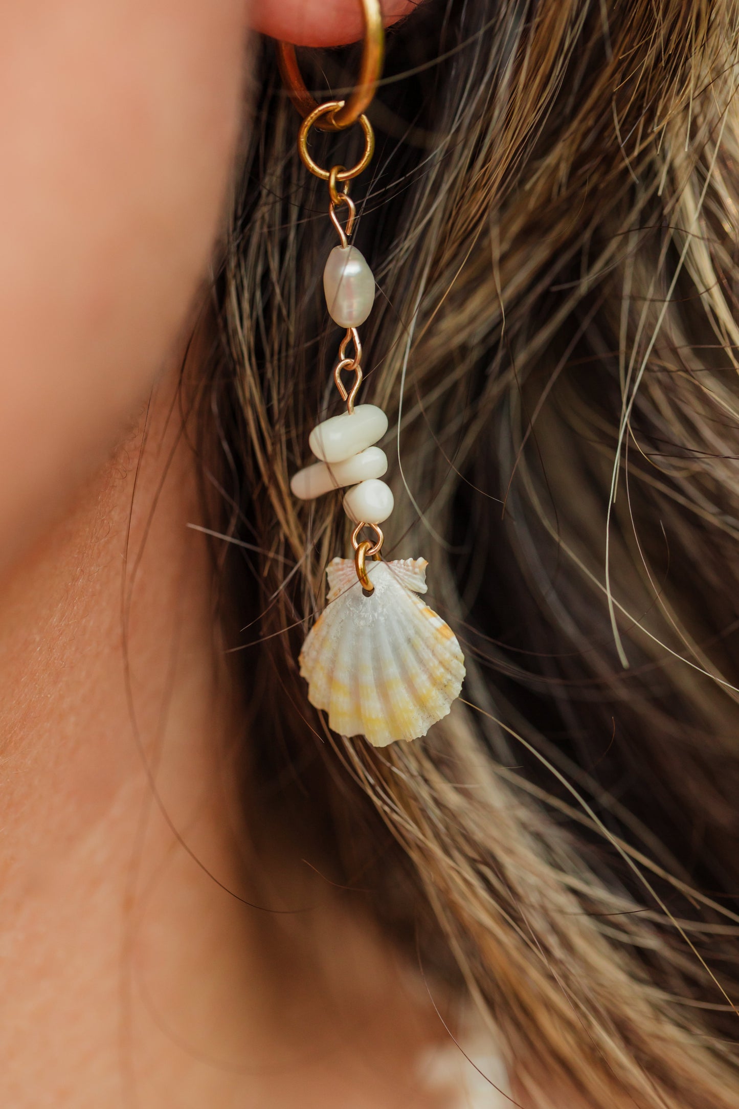 Sunrise Shell Coral Drop Earrings featuring genuine Hawaiian sunrise shells, natural coral chips, freshwater pearls, and 18K Gold PVD hoops inspired by the rare treasures of Hawaii.