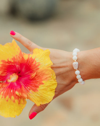 Lavender Bloom white shell bracelet styled in an elegant coastal jewelry look with a natural lavender cone shell centerpiece