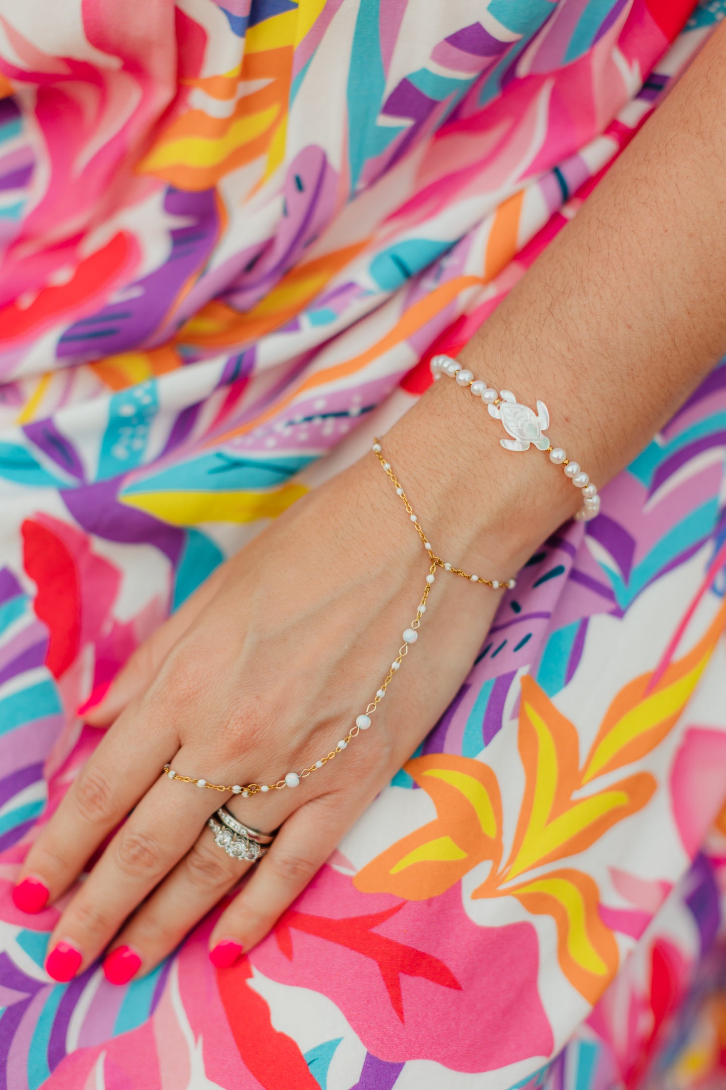 Honu Pearl Bracelet featuring genuine round freshwater pearls, polished 18K gold PVD spacer beads, and a hand-carved mother of pearl sea turtle centerpiece inspired by the treasured sea turtles of Hawaii.