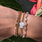 Woman wearing the Pearl Bracelet stacked with other gold and pearl accessories for a chic, sophisticated look.