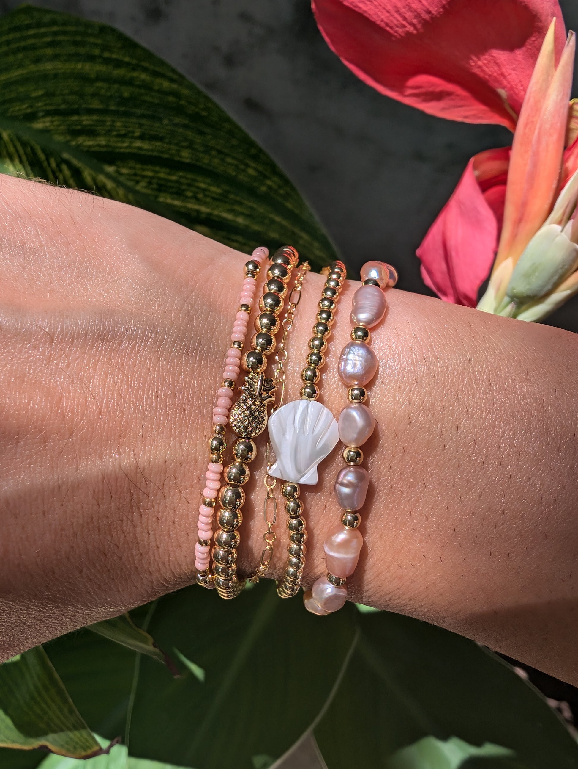 Woman wearing the Pearl Bracelet stacked with other gold and pearl accessories for a chic, sophisticated look.