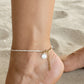 Woman wearing a dainty freshwater pearl anklet with gold accents for coastal everyday style