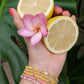 Woman wearing a pink and yellow summer bracelet stack inspired by pool days and lemonade