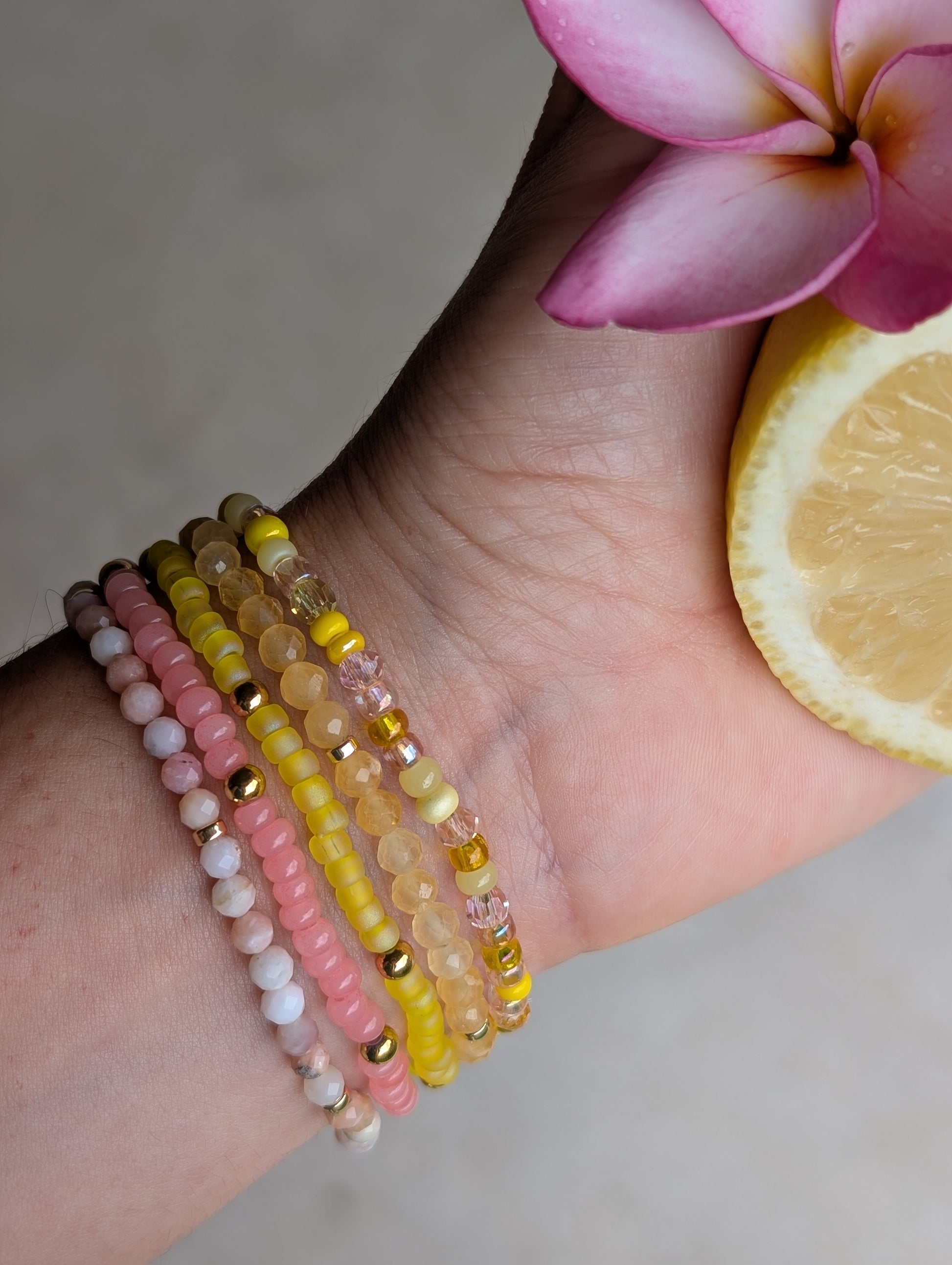 Close-up of Citrus Bloom gemstone bracelet stack with pink opal and citrine beads