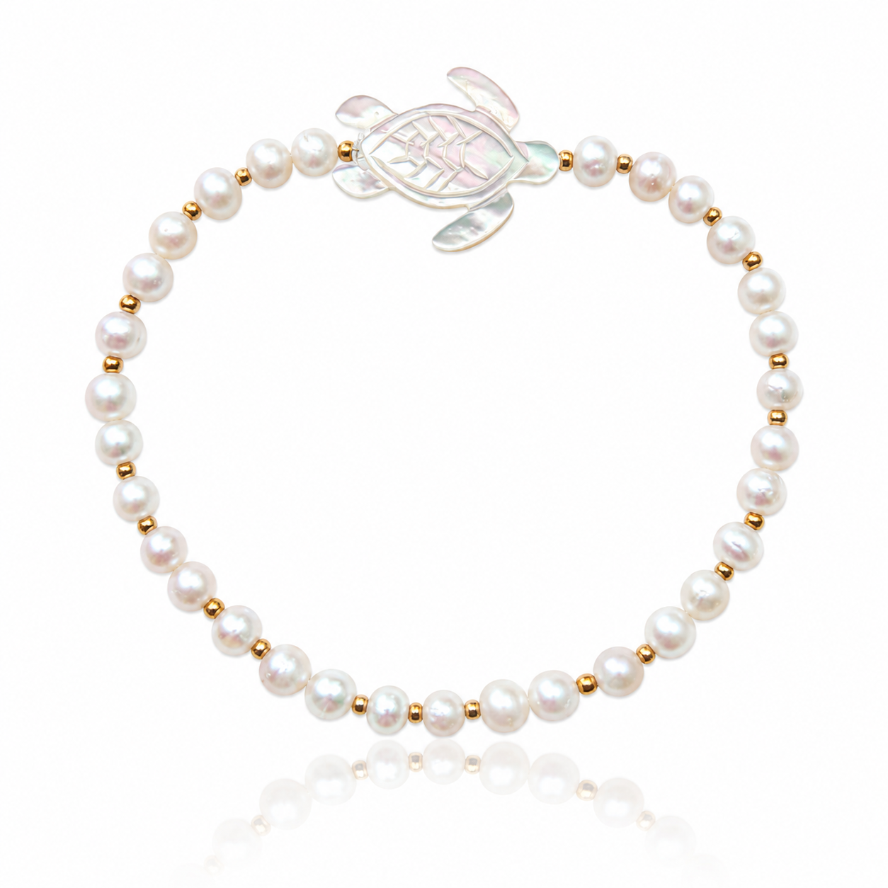 Honu Pearl Bracelet featuring genuine round freshwater pearls, polished 18K gold PVD spacer beads, and a hand-carved mother of pearl sea turtle centerpiece inspired by the treasured sea turtles of Hawaii.