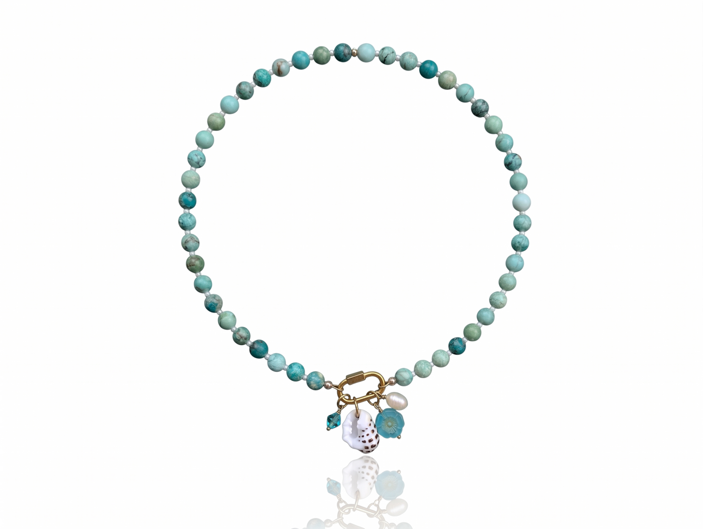 Hand-strung Peruvian turquoise gemstone necklace featuring an 18K Gold PVD oval carabiner clasp with removable charms including a turquoise Swarovski crystal, Czech glass hibiscus, Hawaiian spotted drupe shell, and freshwater pearl.