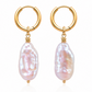 Gold hoop earrings with pink baroque pearls on a white background